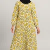 Girls abaya with mustard-yellow floral print on cream, worn with a black hijab